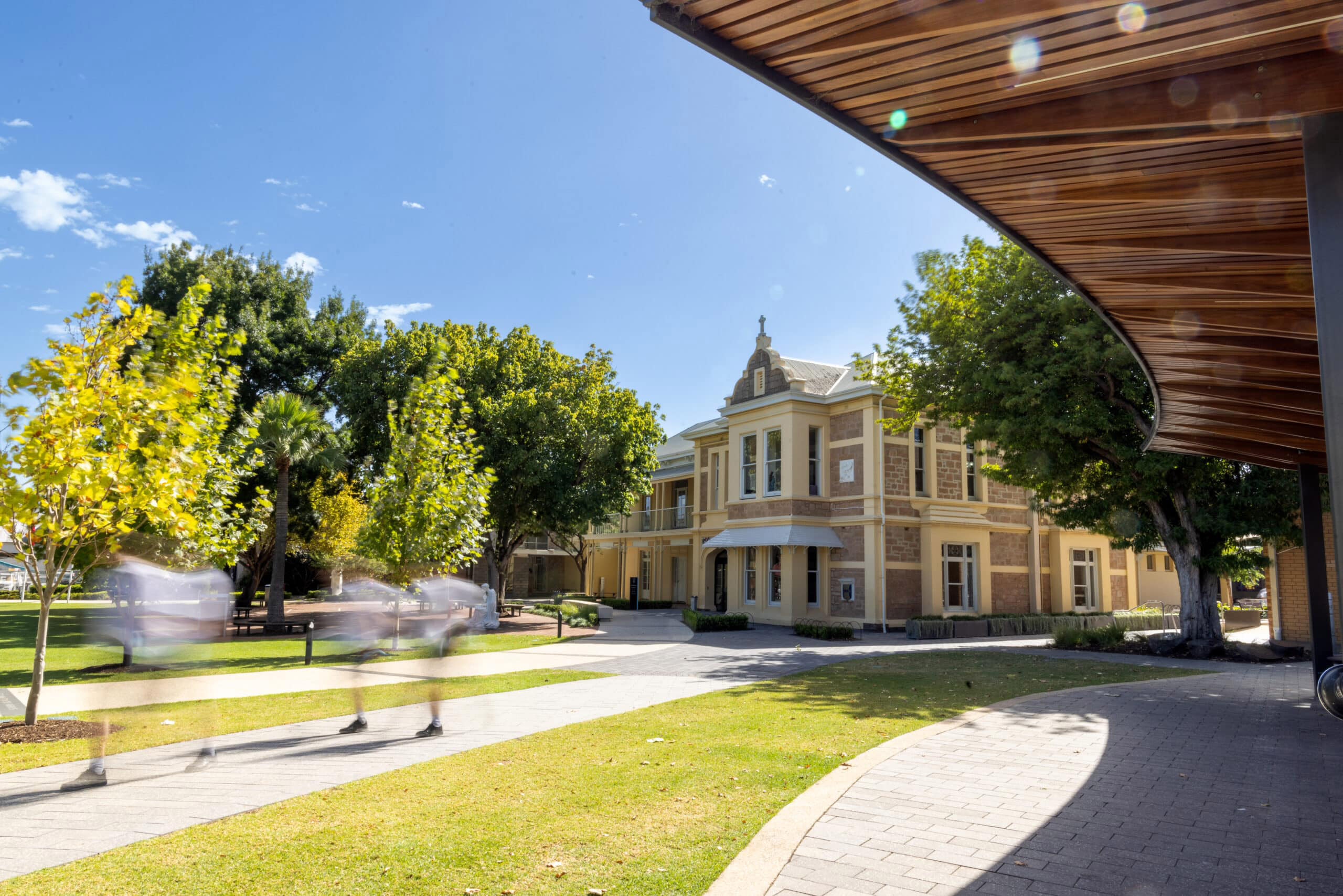 Students crossing the lawn in front of the heritage St Catherine's building at Blackfriars Priory School in Prospect, South Australia