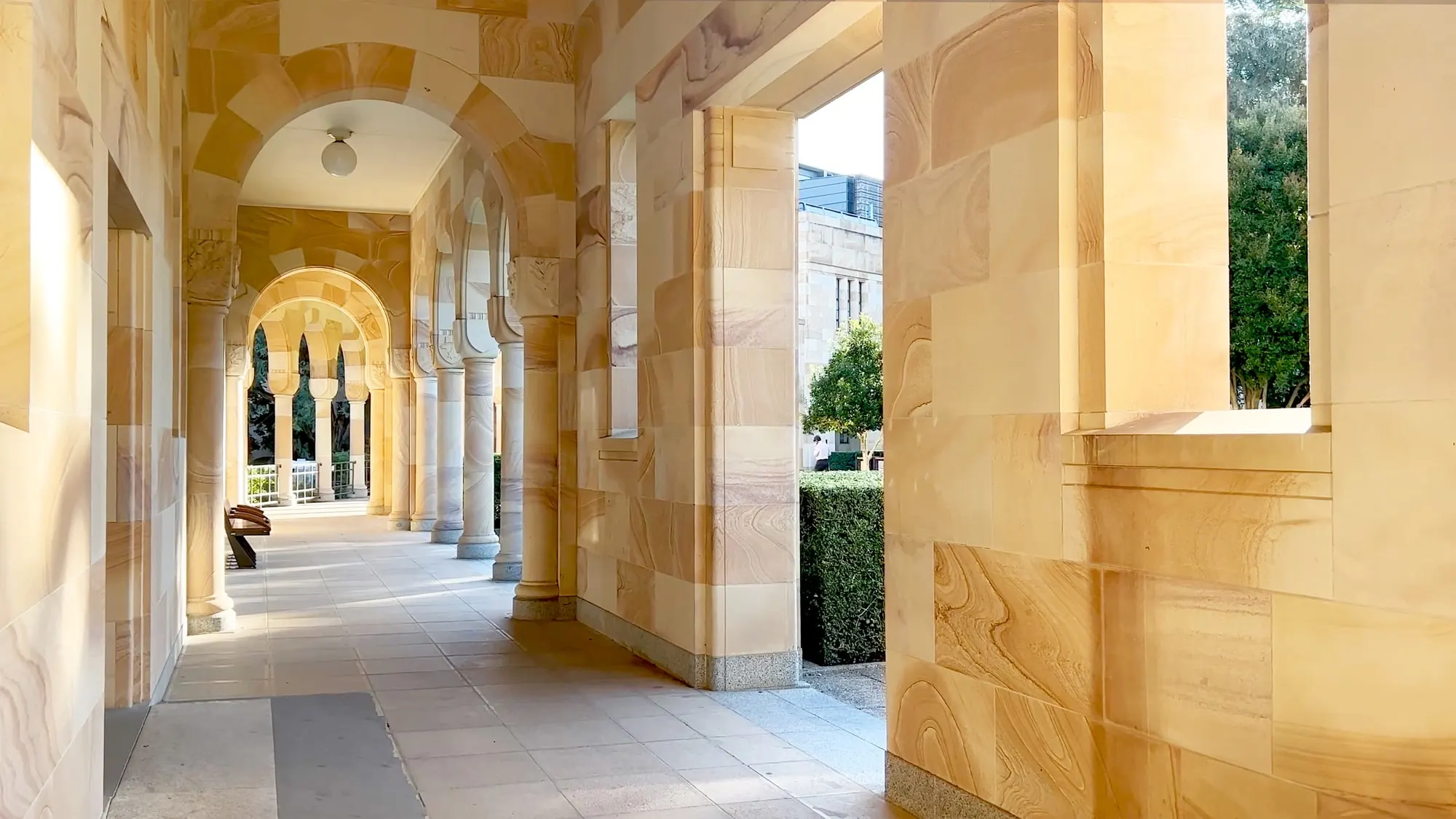 The sandstone cloister of a faith-based school, its arches opening onto a courtyard.