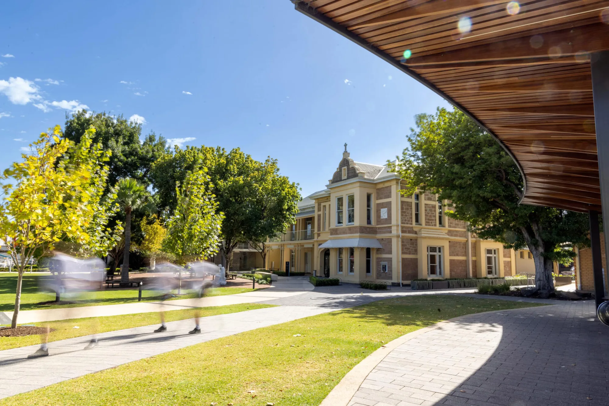 Students crossing the lawn in front of the heritage St Catherine's building at Blackfriars Priory School in Prospect, South Australia